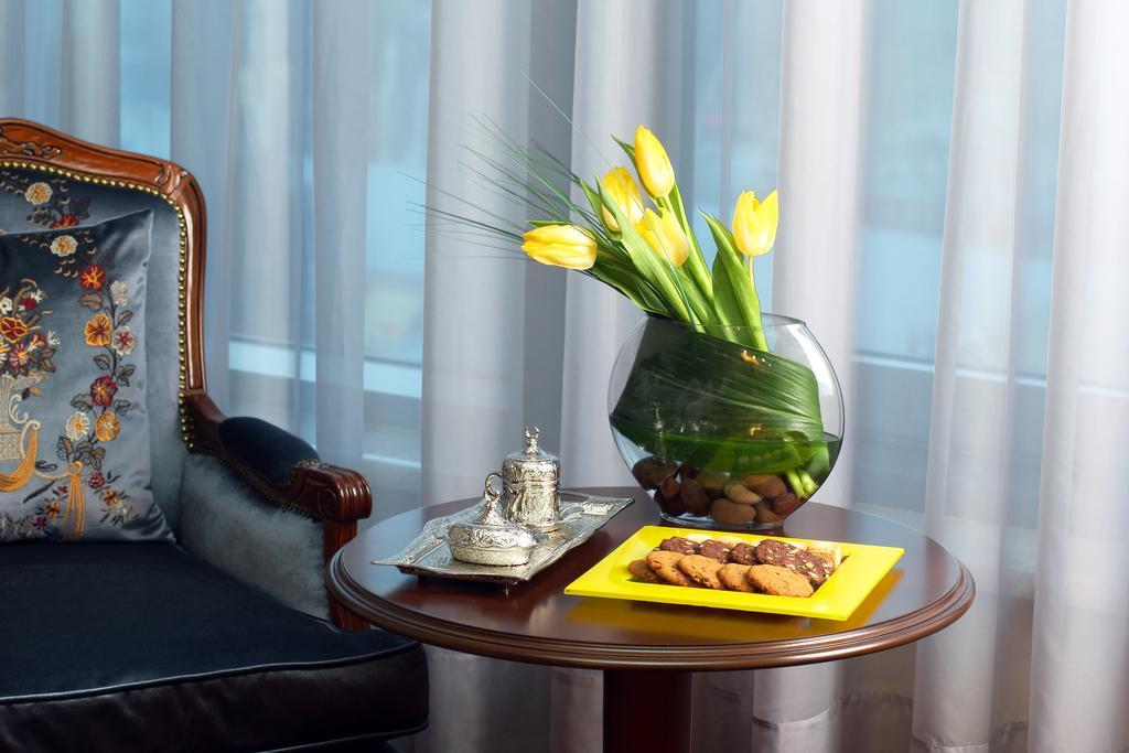 Orion Hotel Bishkek Exterior foto A table with a vase of flowers